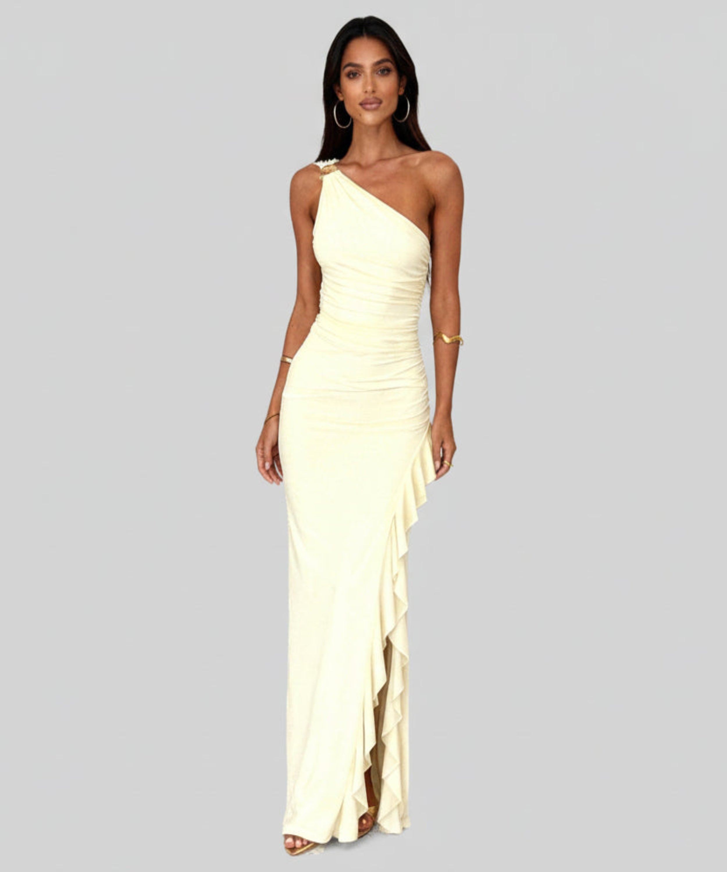 Woman wearing a one-shoulder ivory dress on a light grey background
