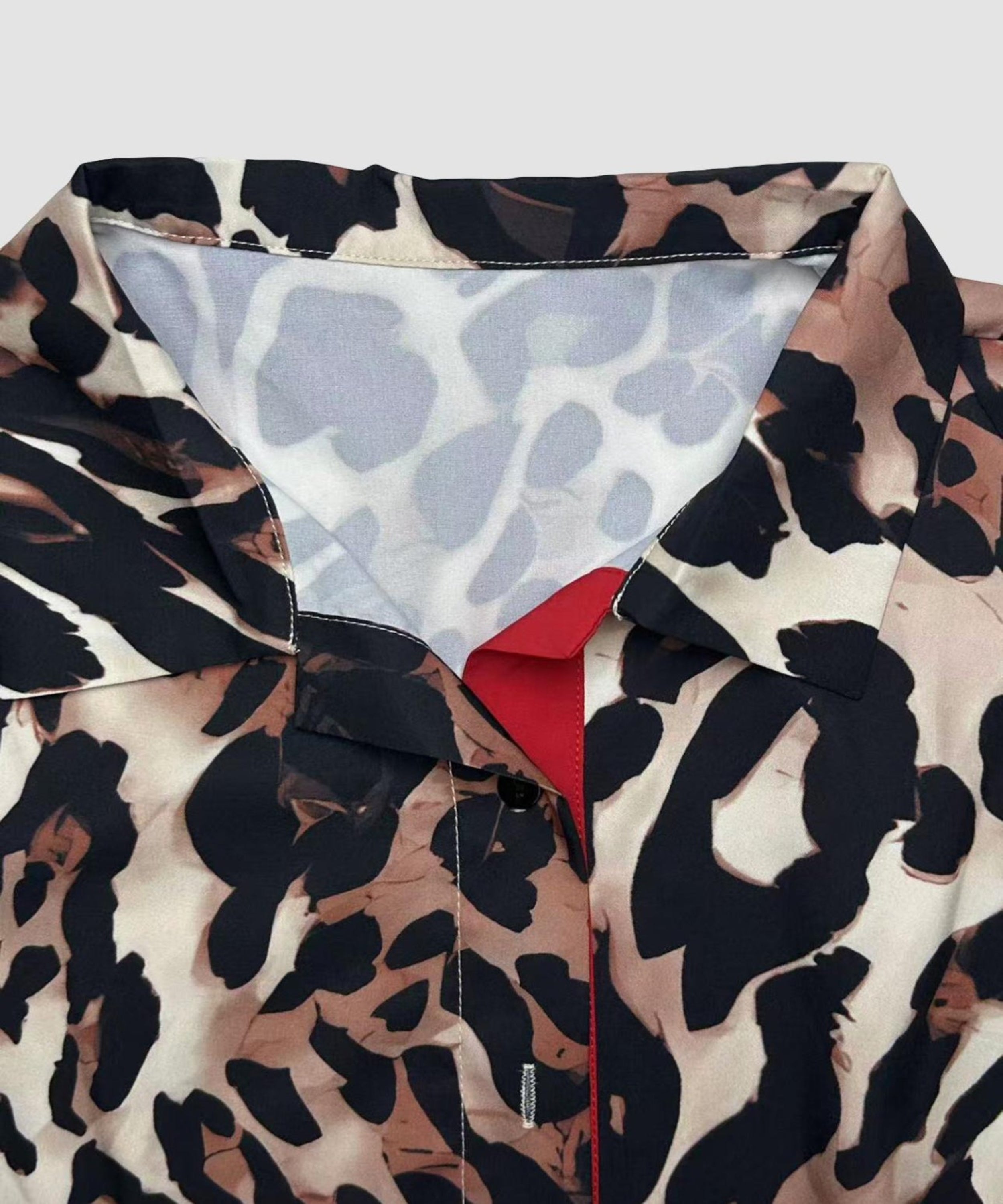 Leopard print jacket with a red interior lining on a light gray background