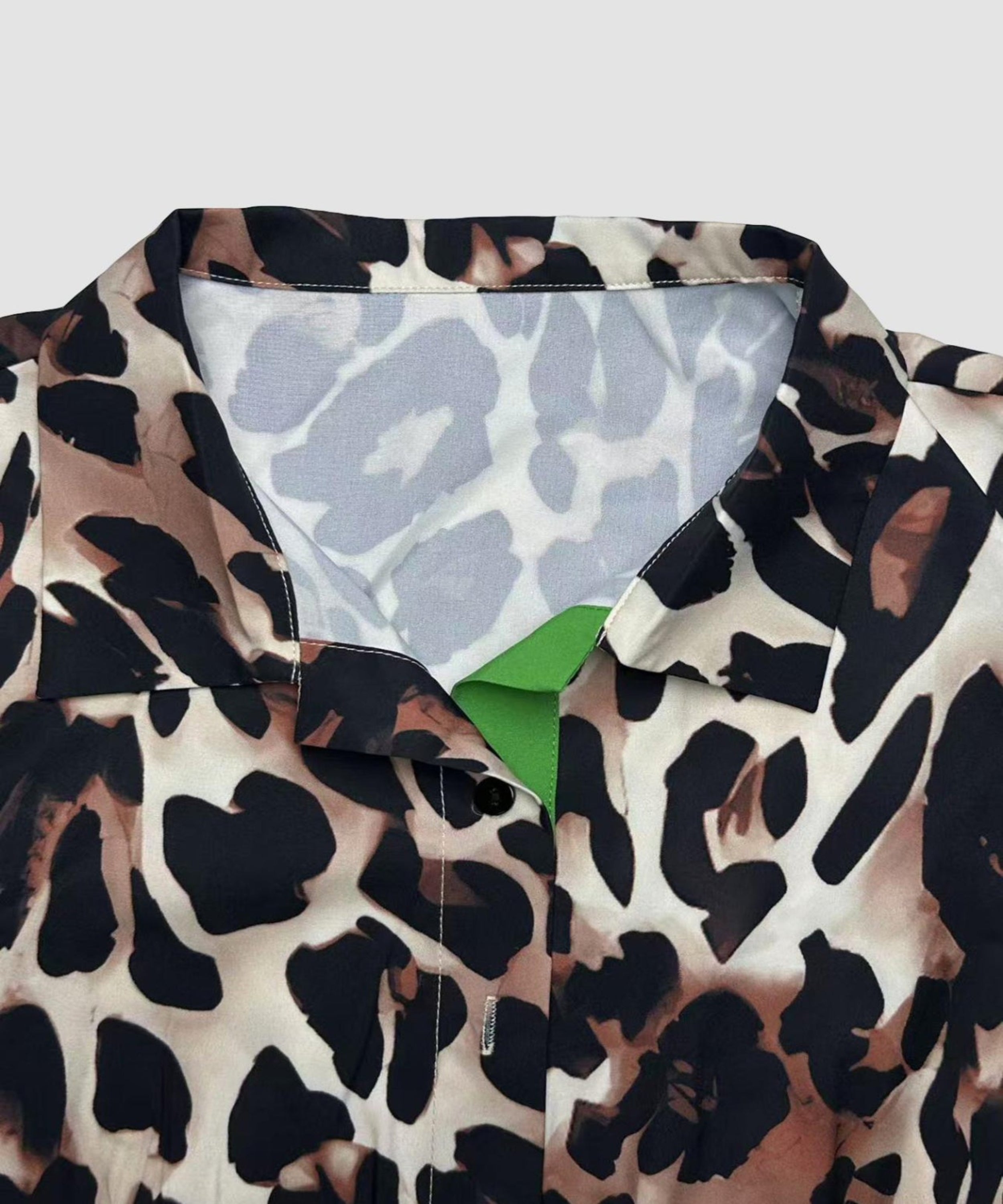Leopard print jacket with a green lining on a light gray background