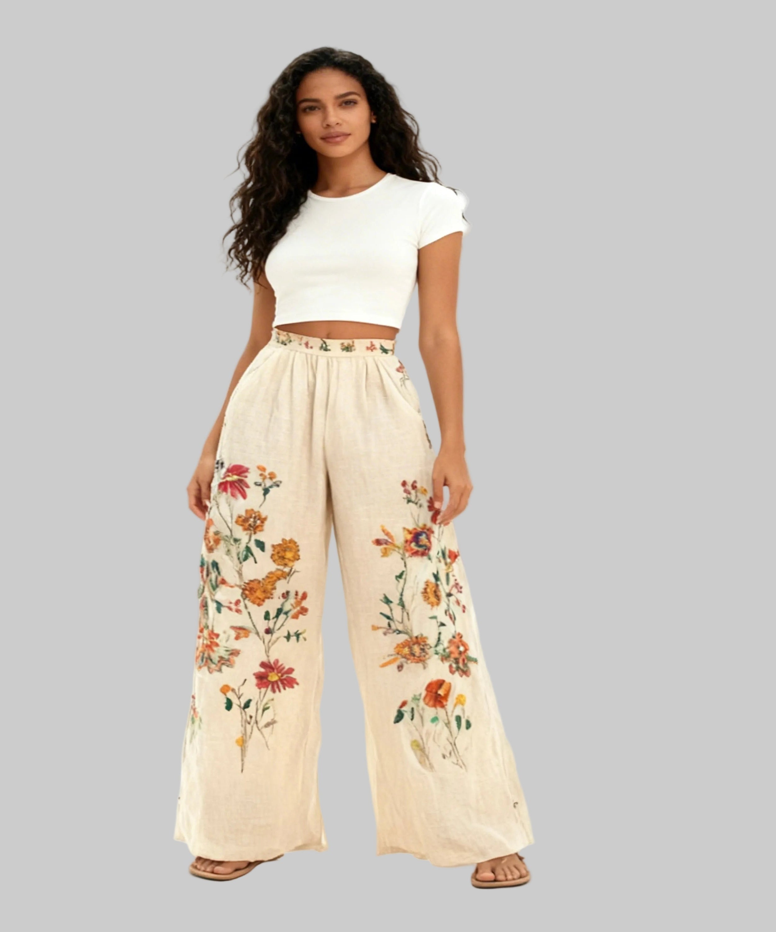 Woman wearing a white top and floral pants on a white background