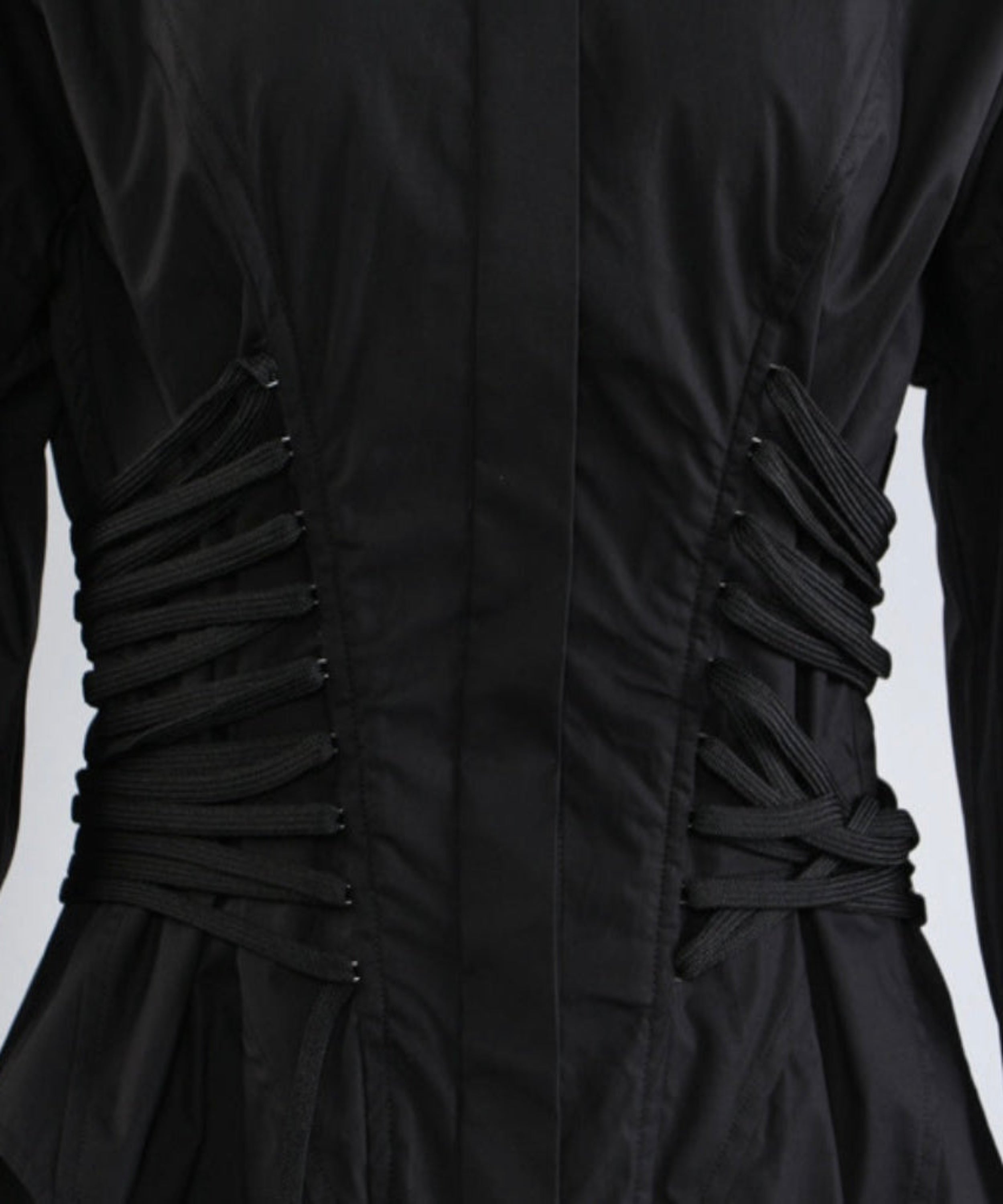 Close-up of a black dress with ruched back on a light gray background