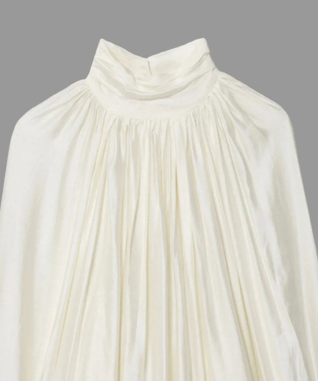White blouse with long sleeves on a light gray background