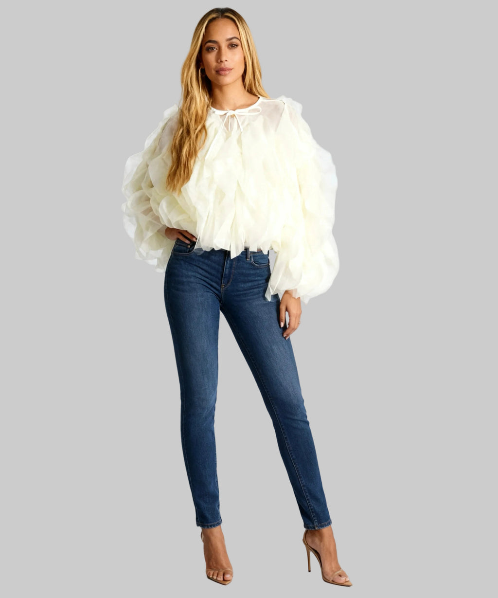 women wearing yellow top, jeans and heels on a white background
