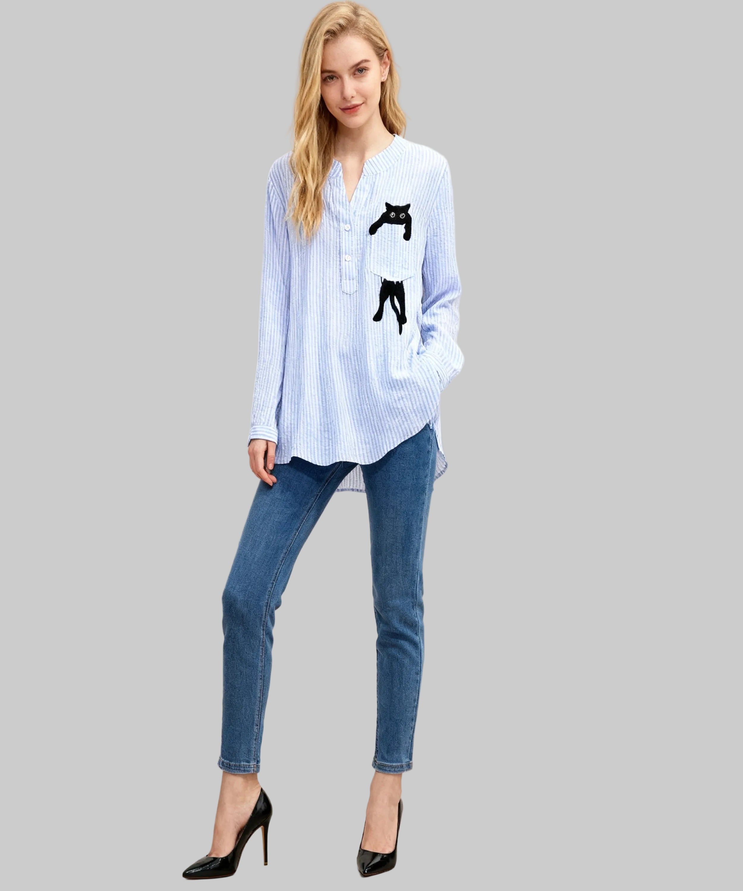 Woman wearing a light blue striped shirt with black cat designs and blue jeans on a beige background