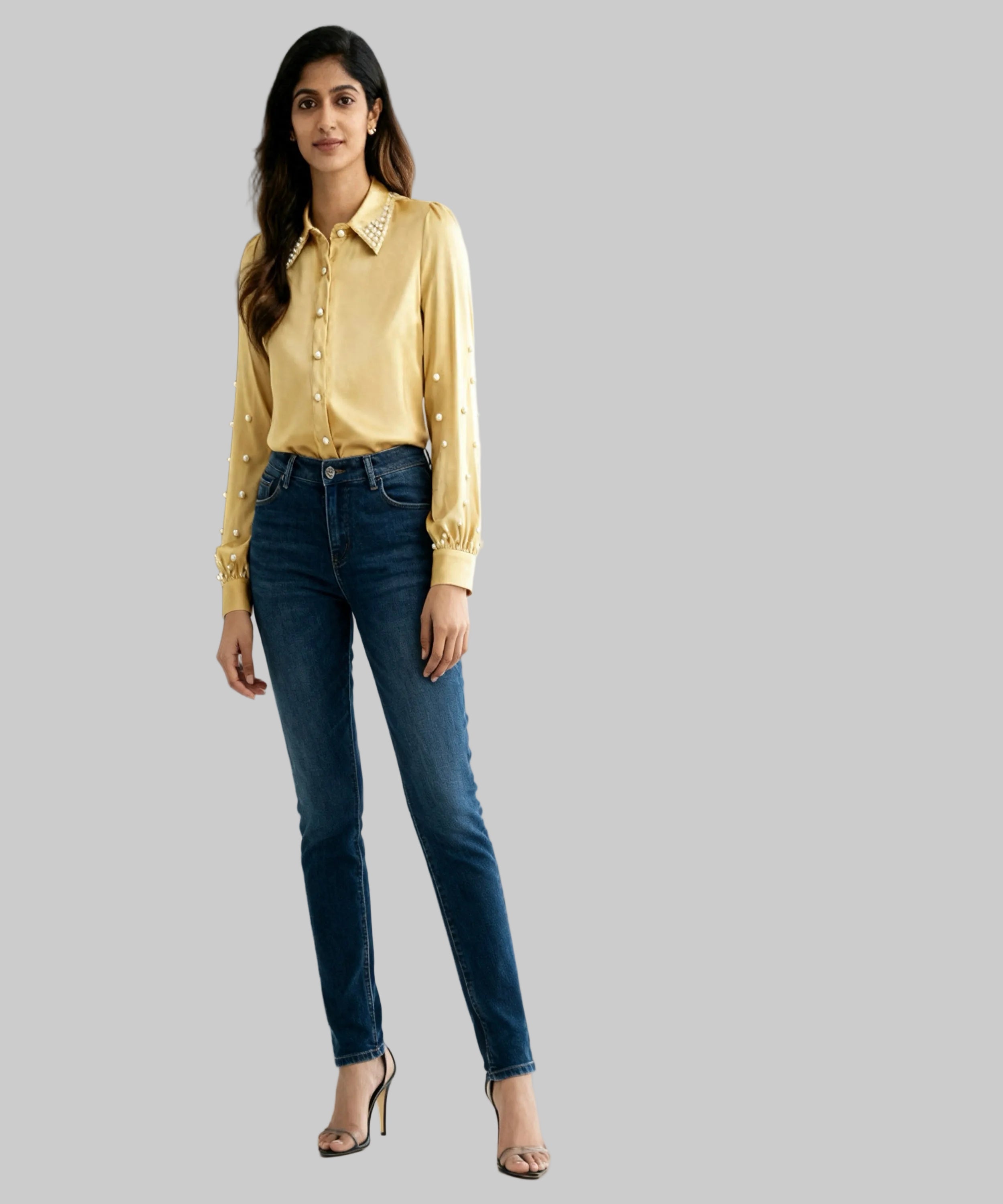 Woman wearing a yellow blouse and blue jeans against a white background