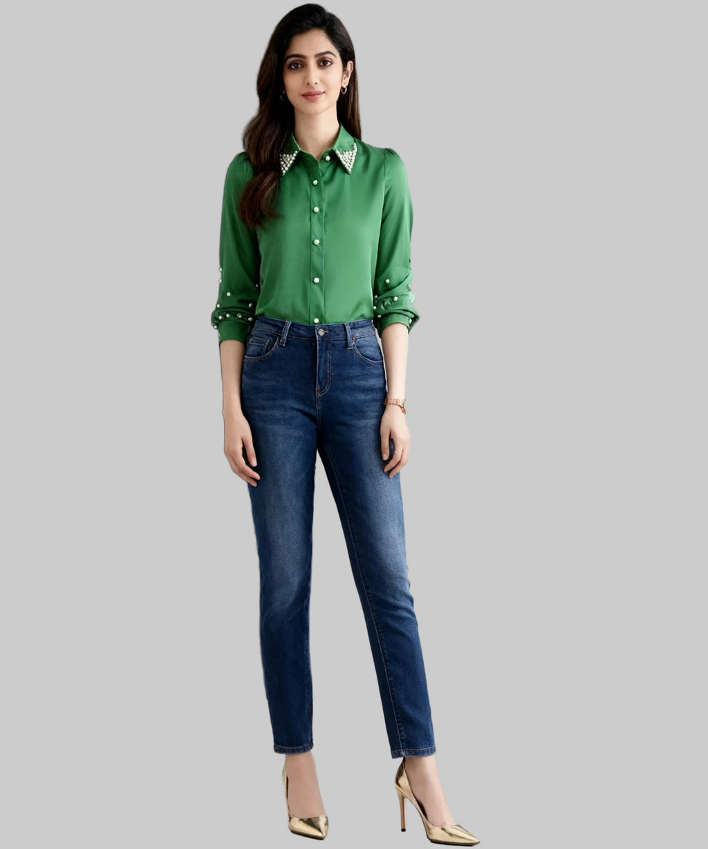 Woman wearing a green shirt and blue jeans against a gray background