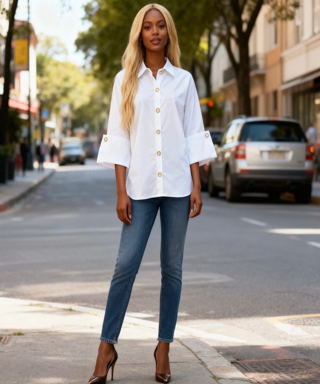 Woman wearing a white shirt and blue jeans on a city street.