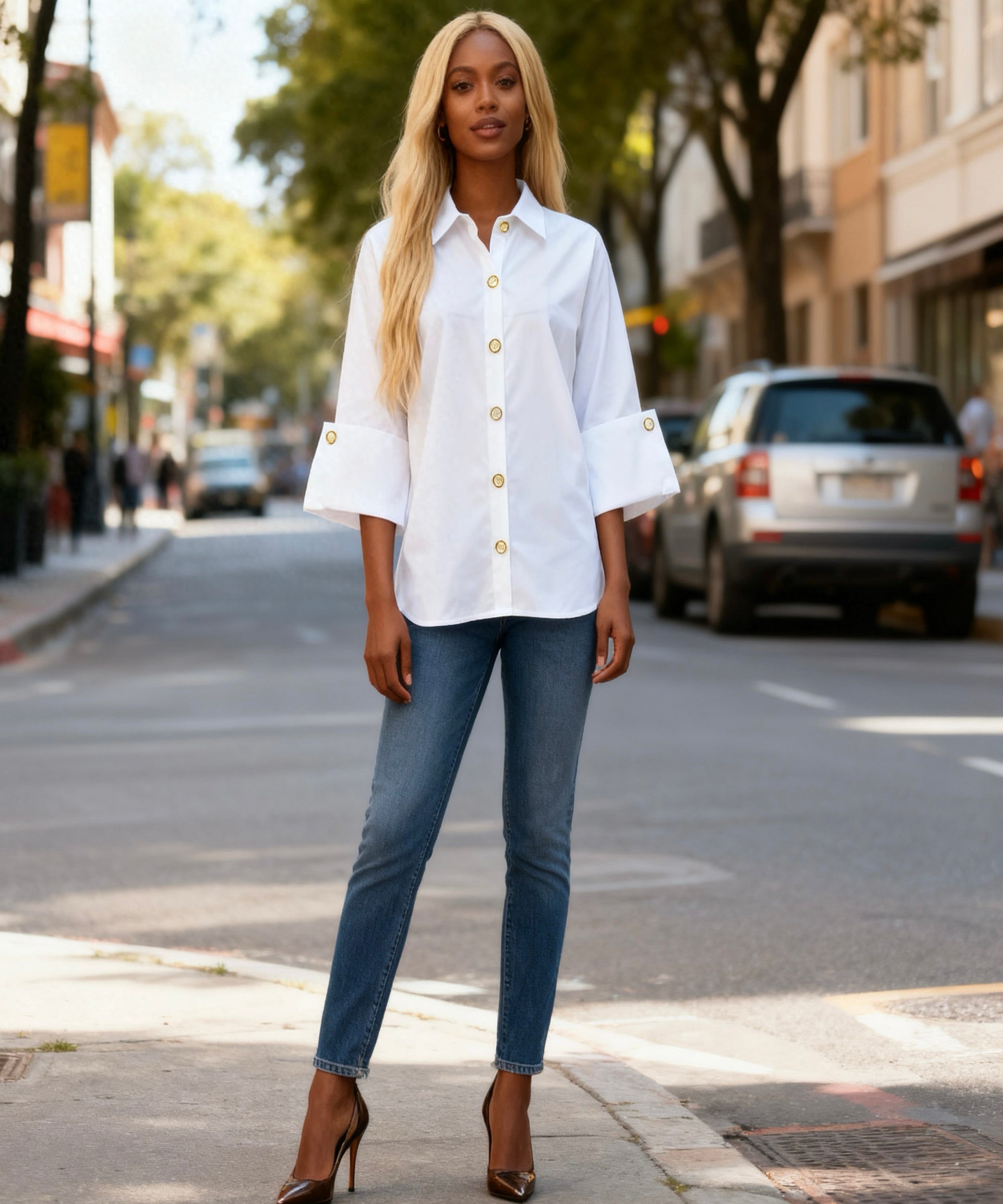 Woman wearing a white shirt and blue jeans on a city street.