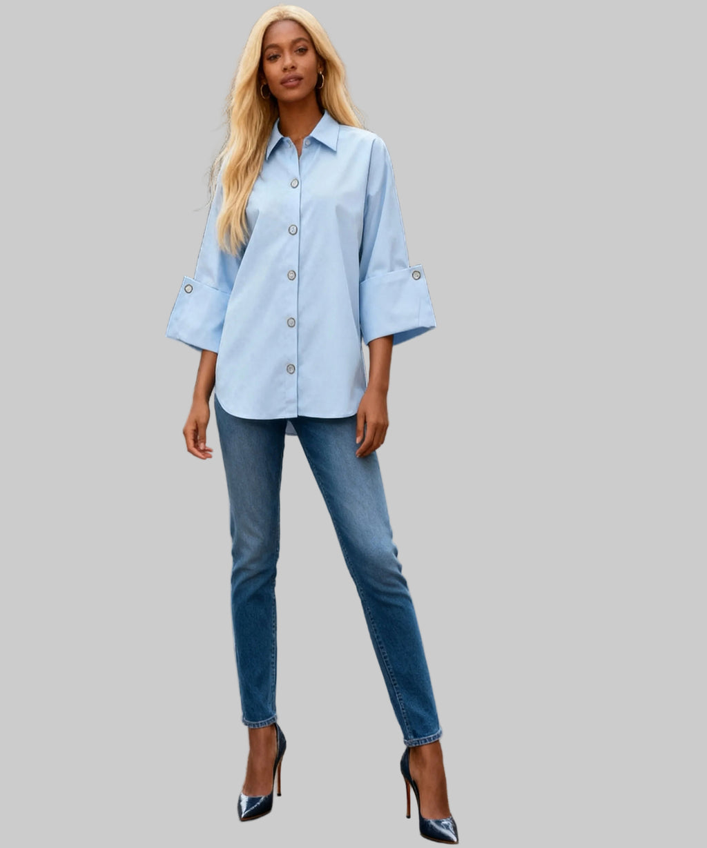 Woman wearing a light blue shirt and jeans standing on a white background