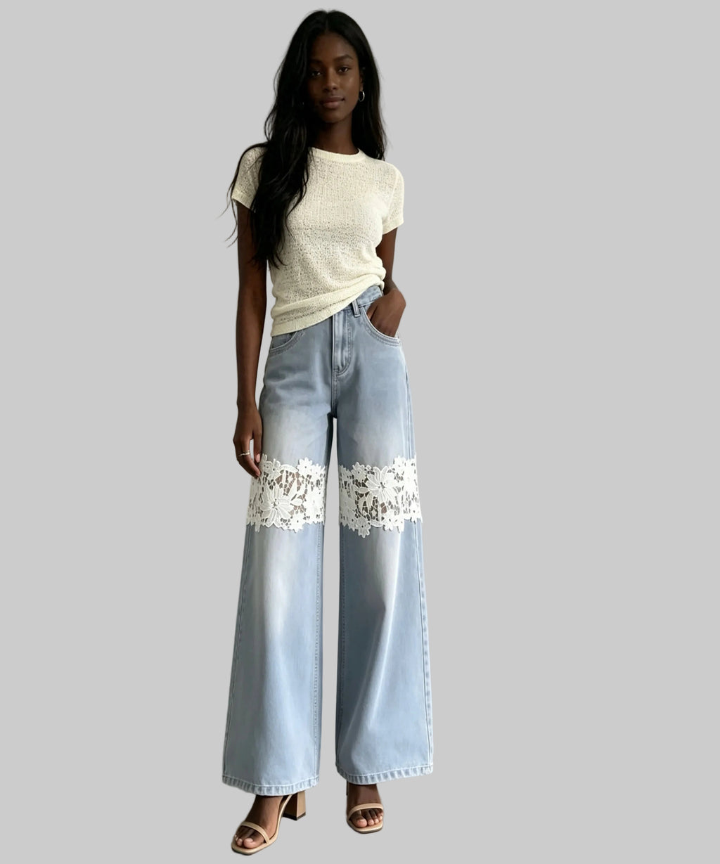 Woman wearing light blue jeans with lace details and a white top against a plain background
