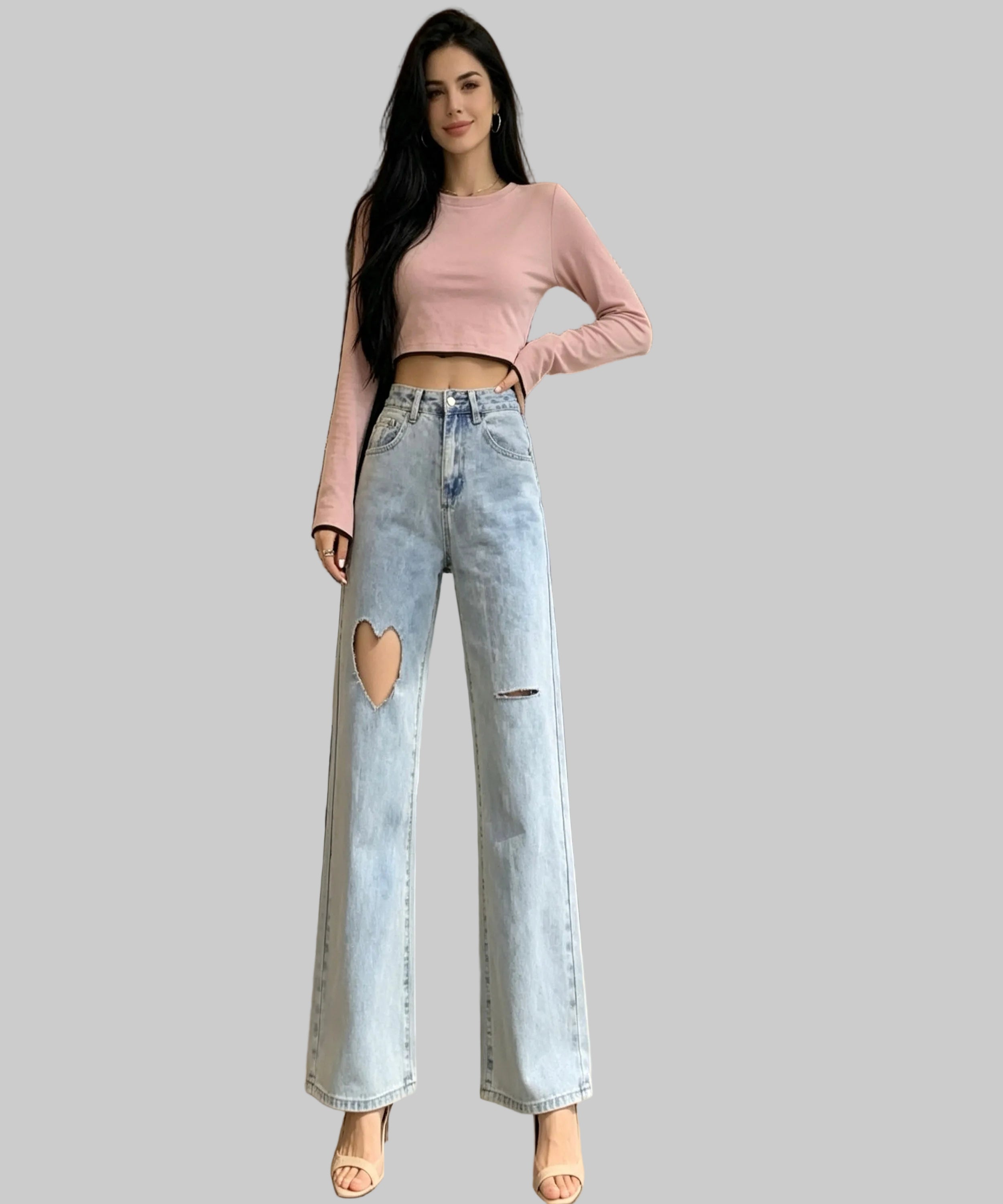 Woman wearing a pink top and light blue jeans with a heart cutout on a patio.