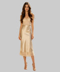 Woman in a beige dress standing on a white background
