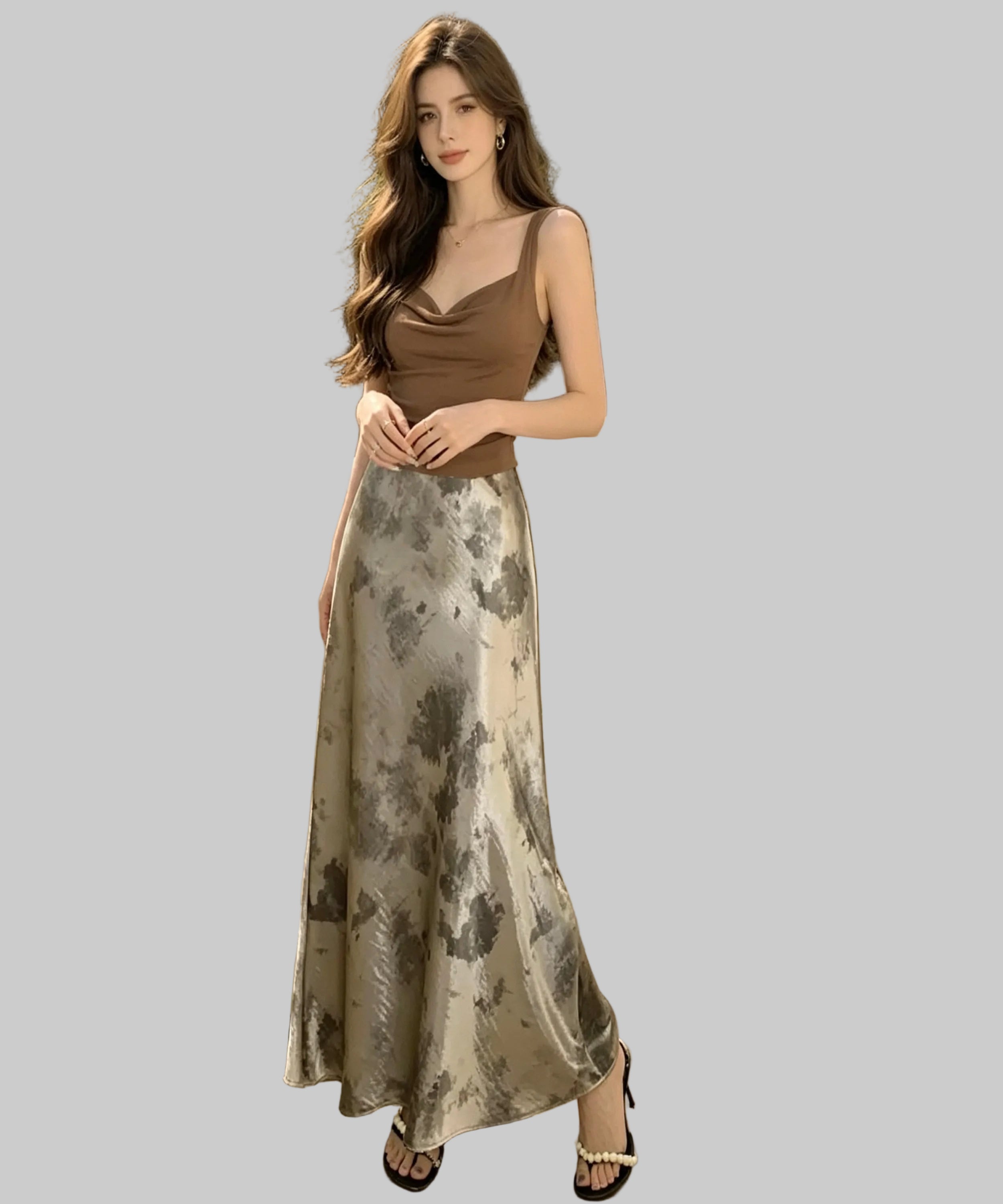Woman in a brown top and floral skirt standing on a white background