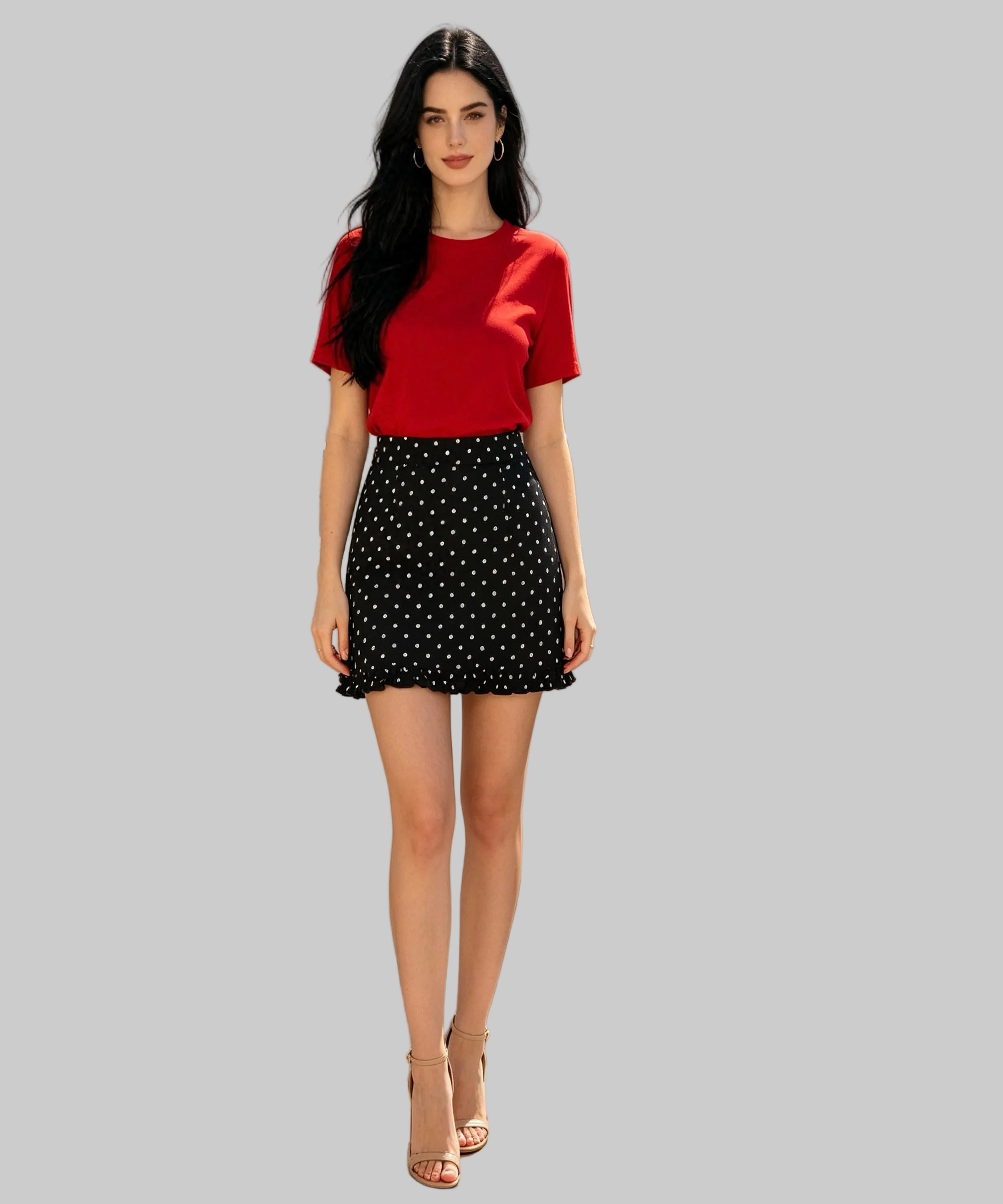 Woman in red top and black polka dot skirt standing on white  background