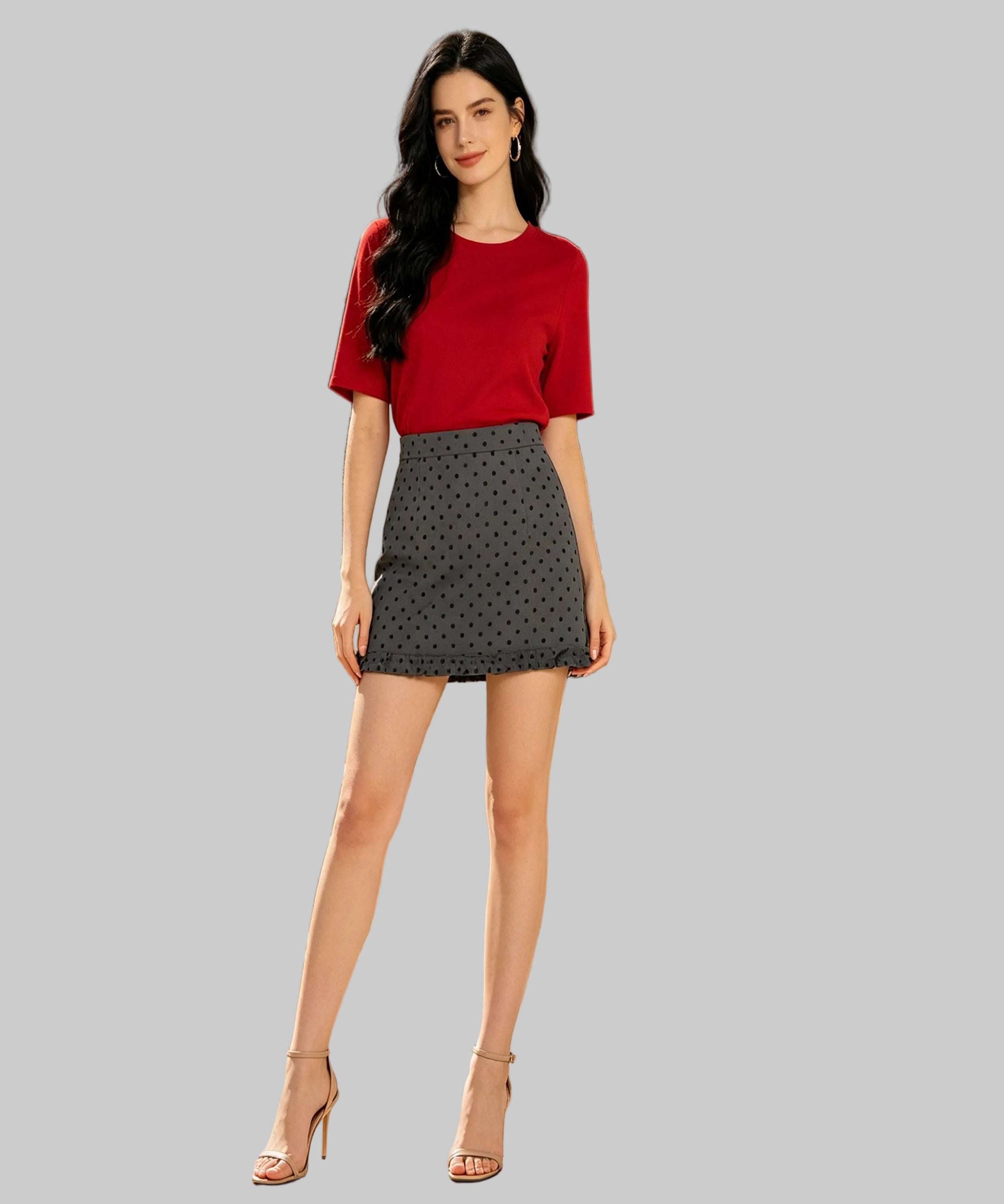 Woman in a red top and patterned skirt standing on white background