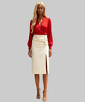 Woman wearing a red blouse and white skirt on a white background