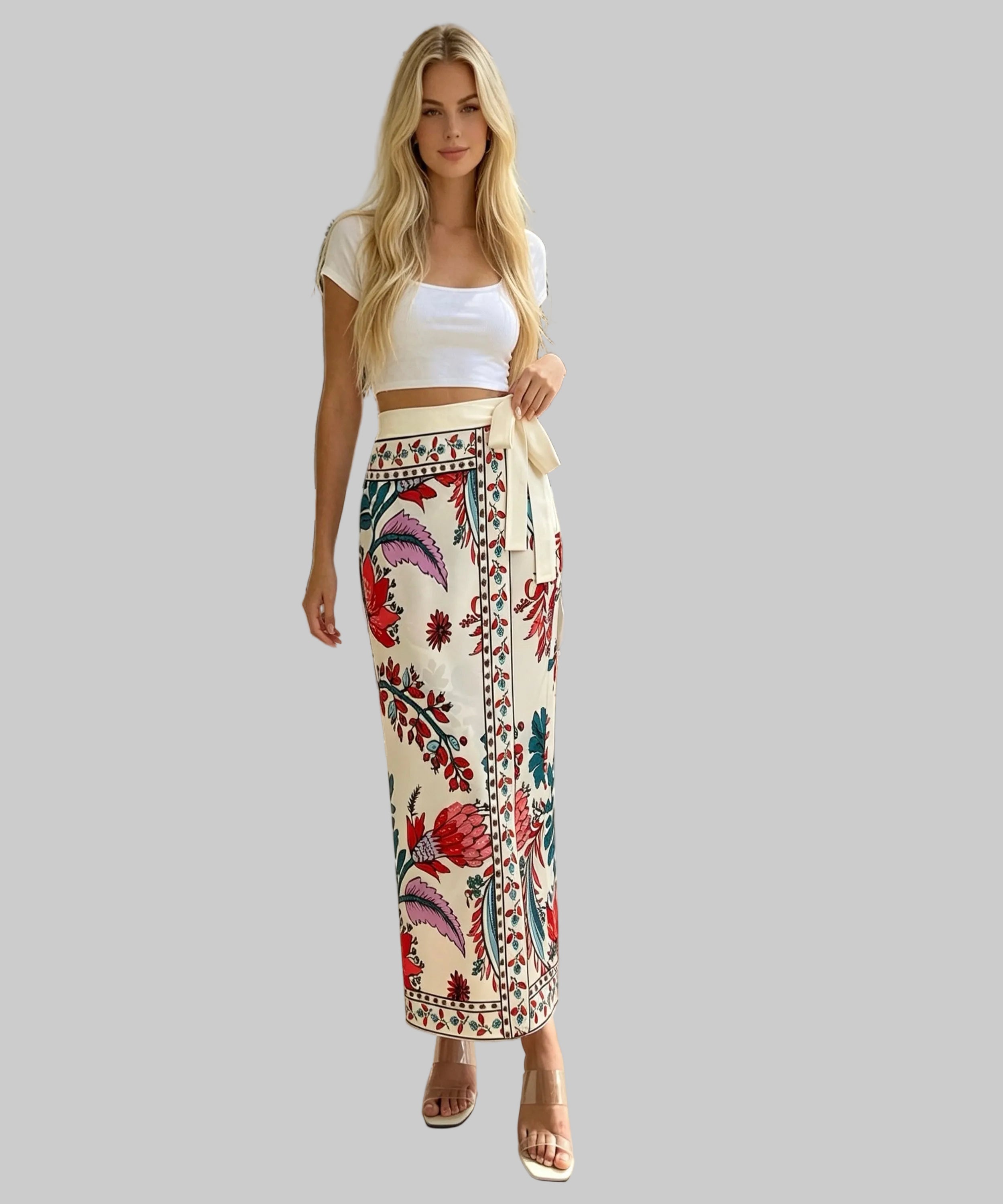 Woman wearing a white top and colourful embroidered skirt on a white background