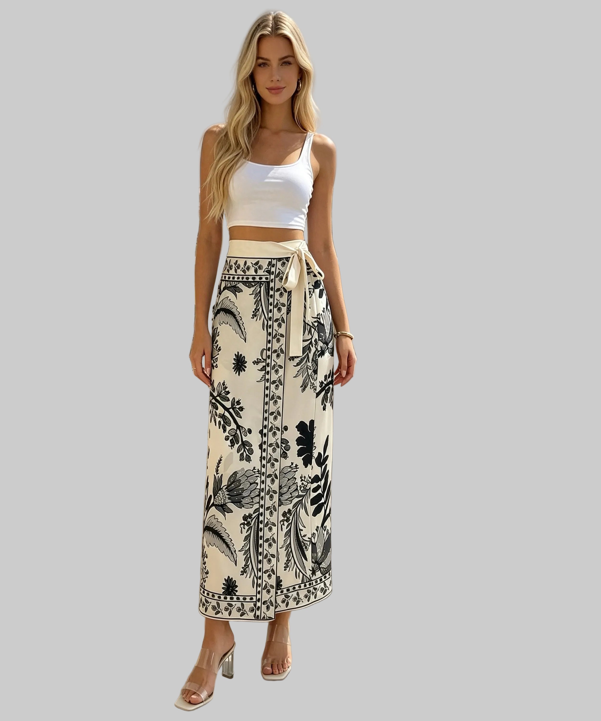 Woman in a white top and patterned skirt standing on a white background