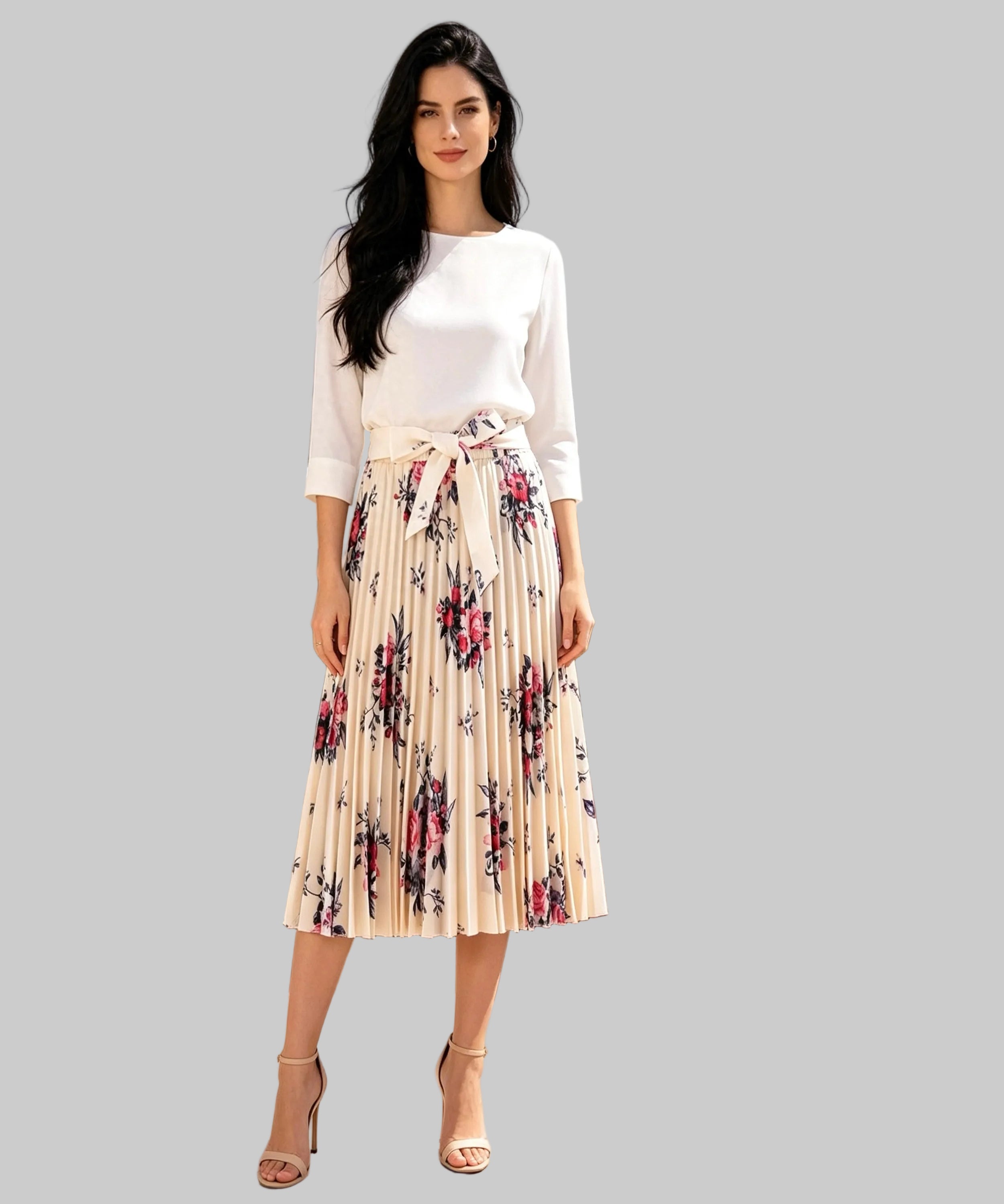 Woman in a white top and floral skirt standing on a white background