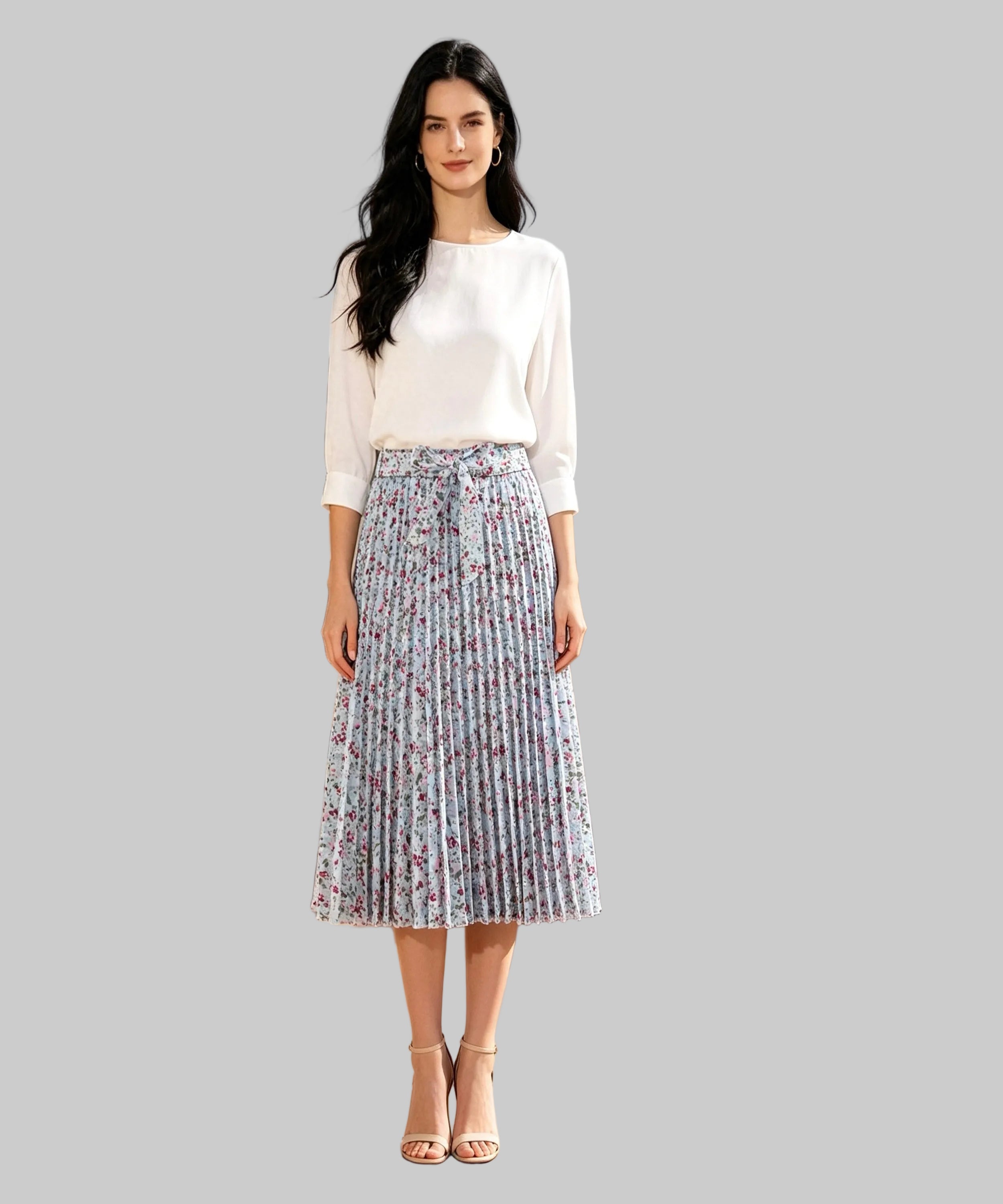 Woman in a white blouse and floral skirt standing on a white background