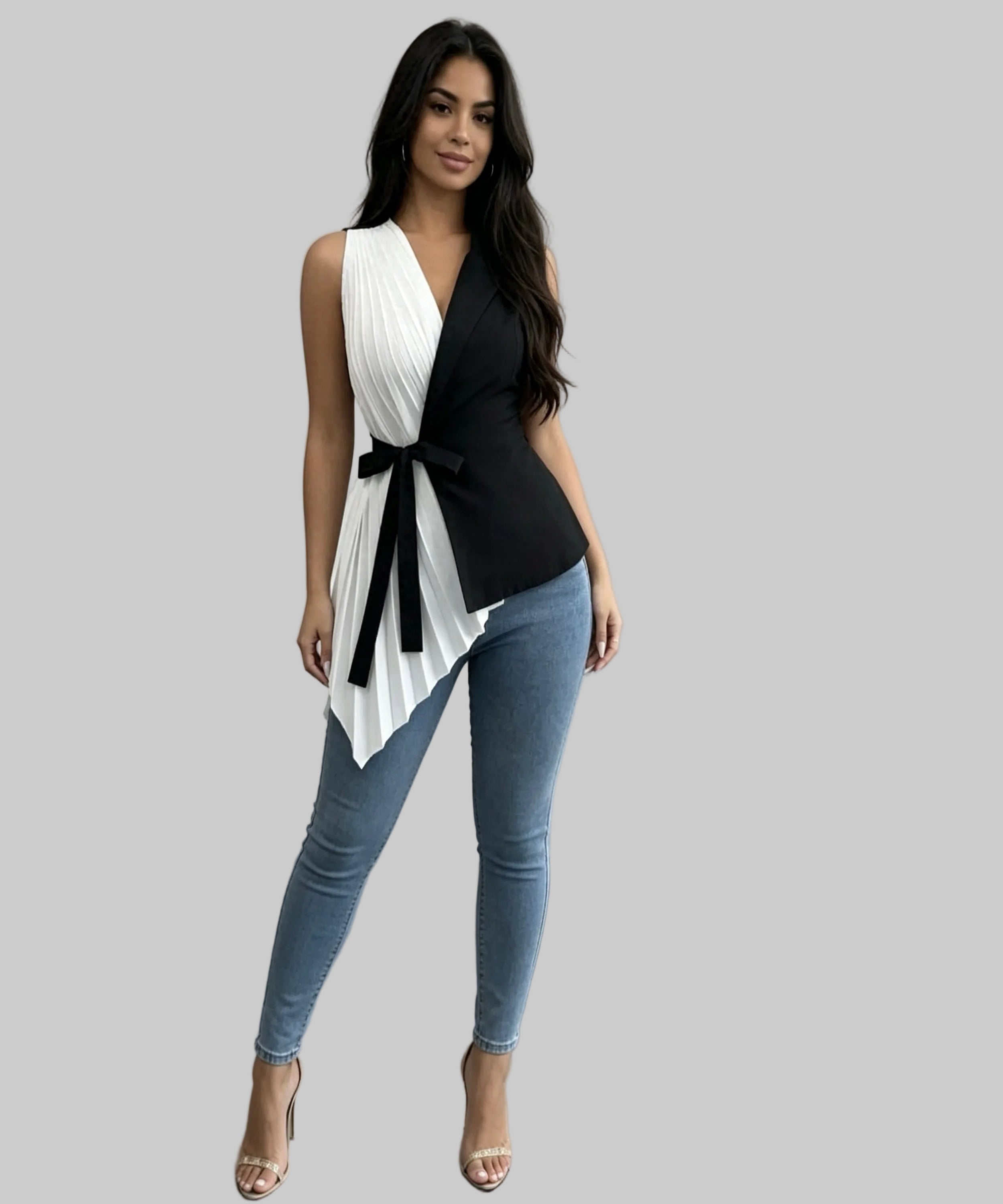 Woman wearing a black and white top with blue jeans in a minimalistic setting
