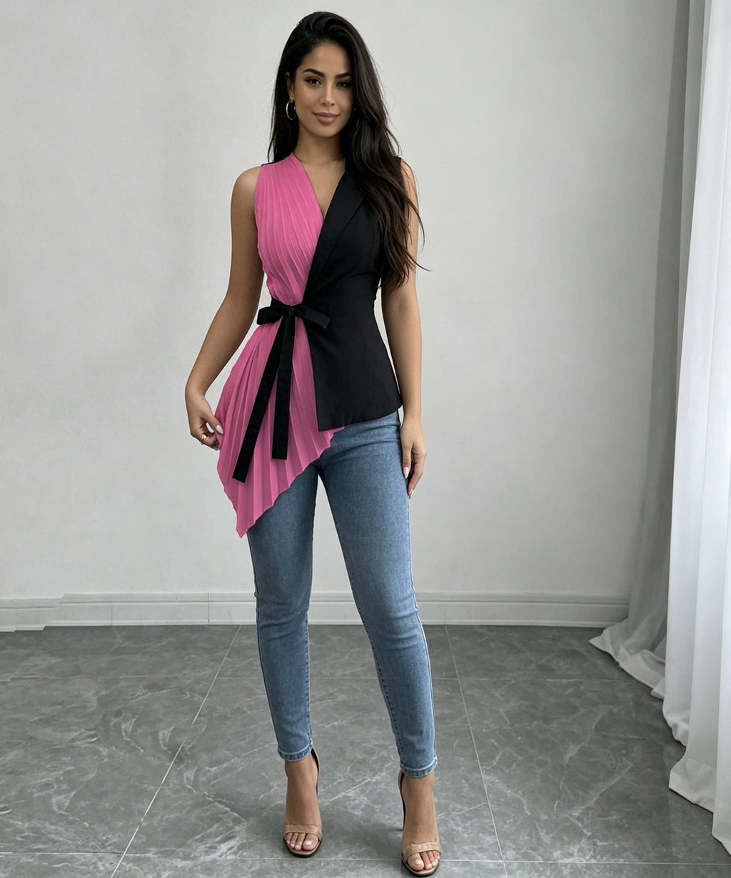 Woman wearing a pink and black sleeveless top with blue jeans in a neutral setting