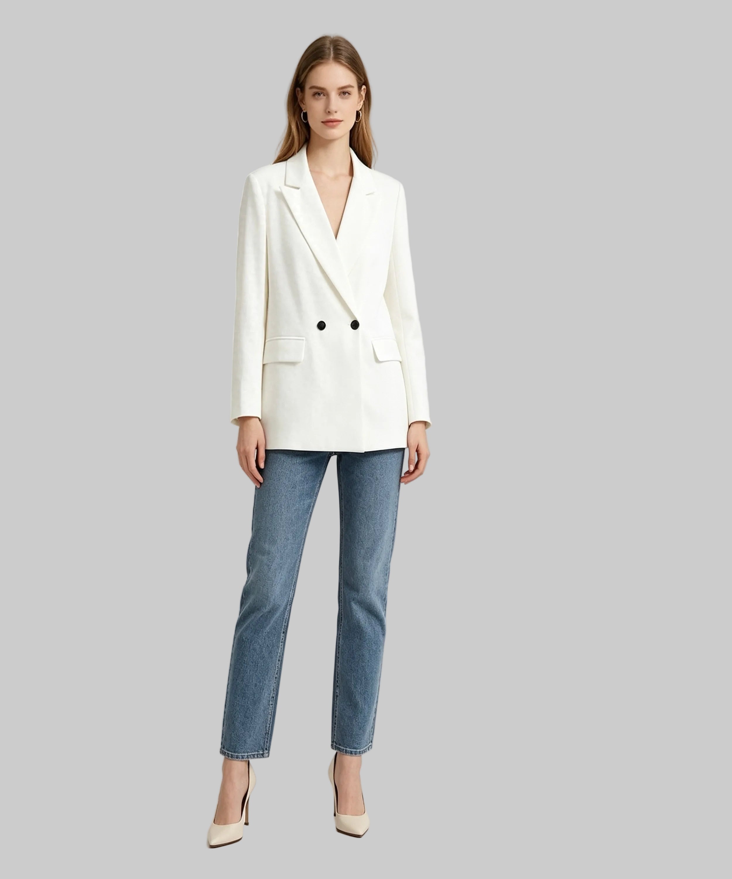 Woman wearing a white blazer and blue jeans on a light gray background