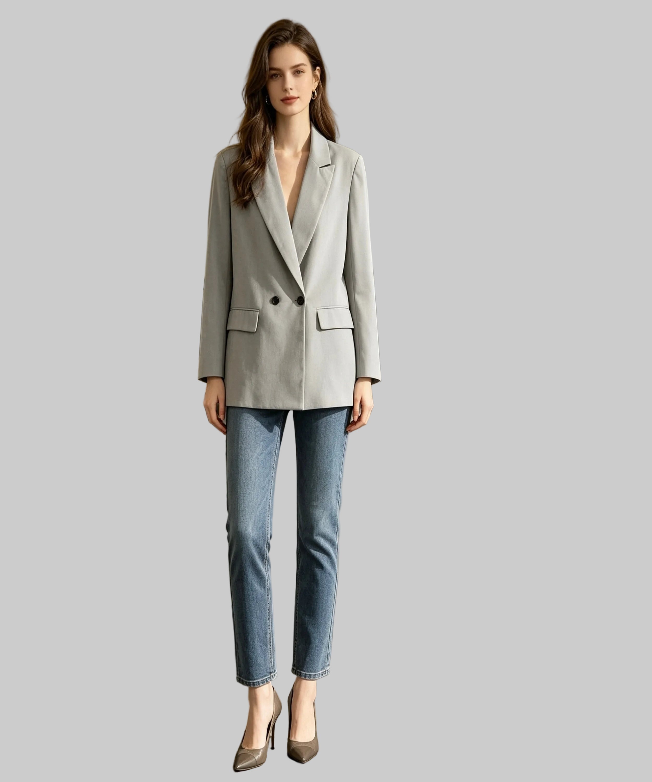 Woman in a gray blazer and blue jeans standing in an office setting