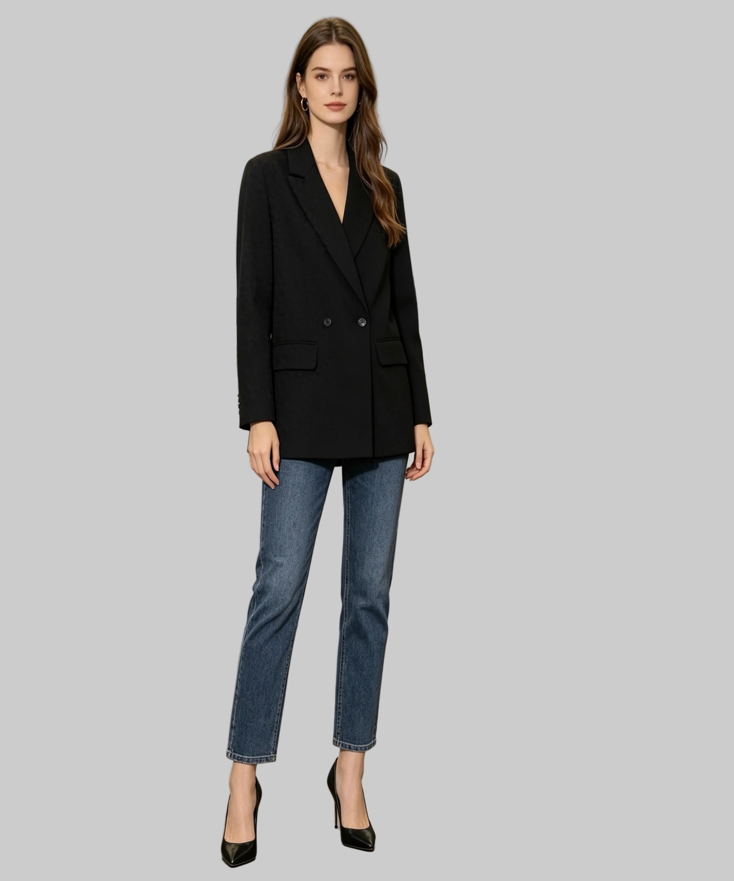 Woman in a black blazer and blue jeans standing in an office setting