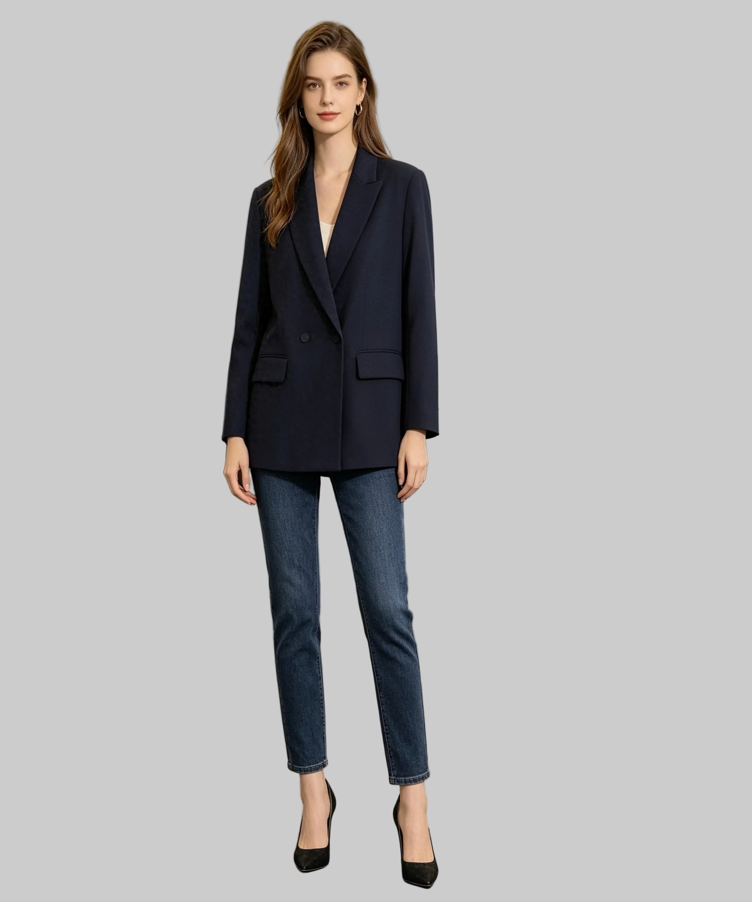 Woman in a navy blazer and blue jeans standing in an office setting