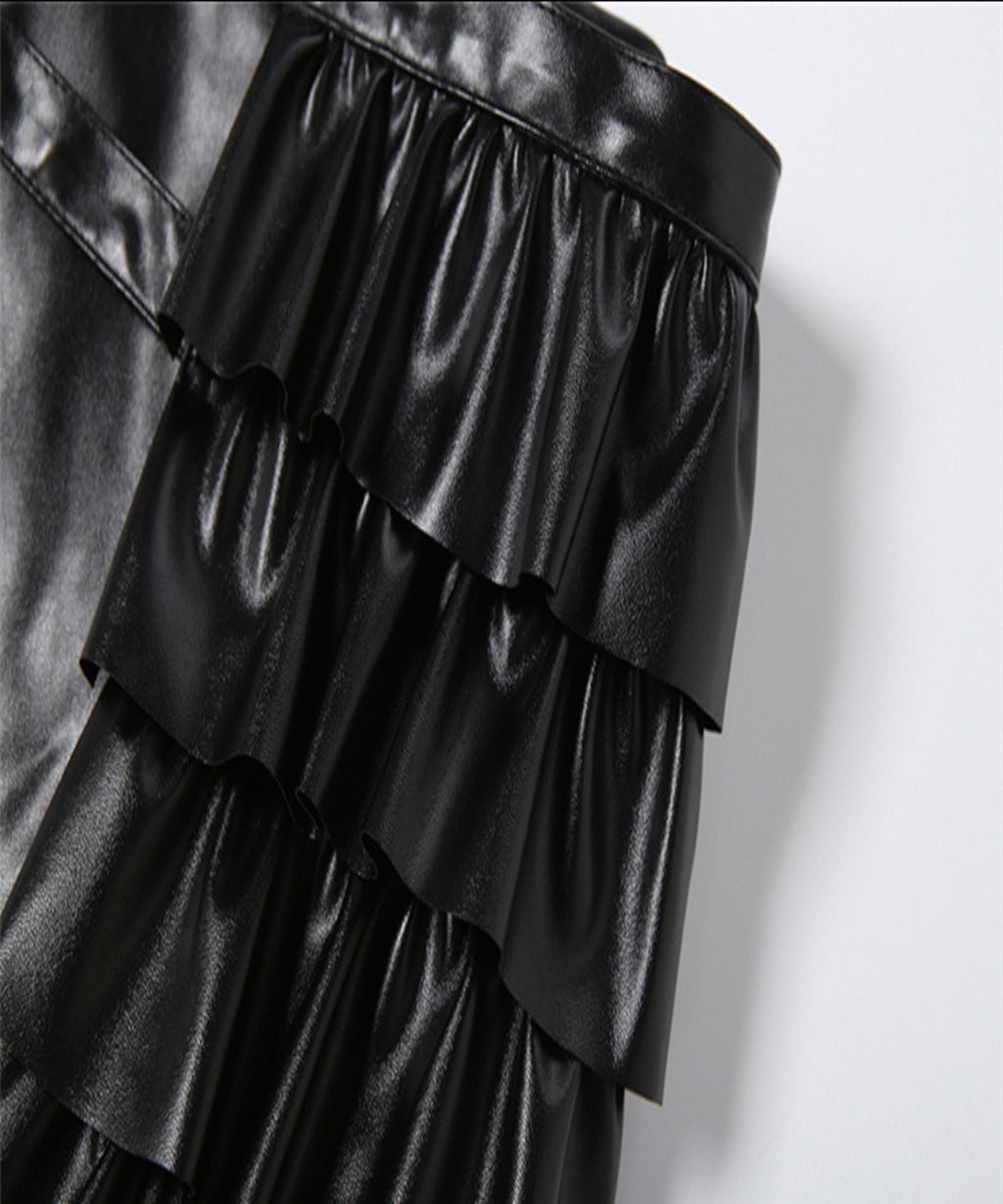 Black leather ruffled skirt on a light gray background
