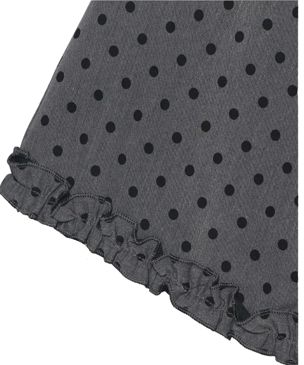 Black polka dot fabric with ruffled edge on a white background