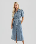 Woman wearing a denim dress on a light grey background