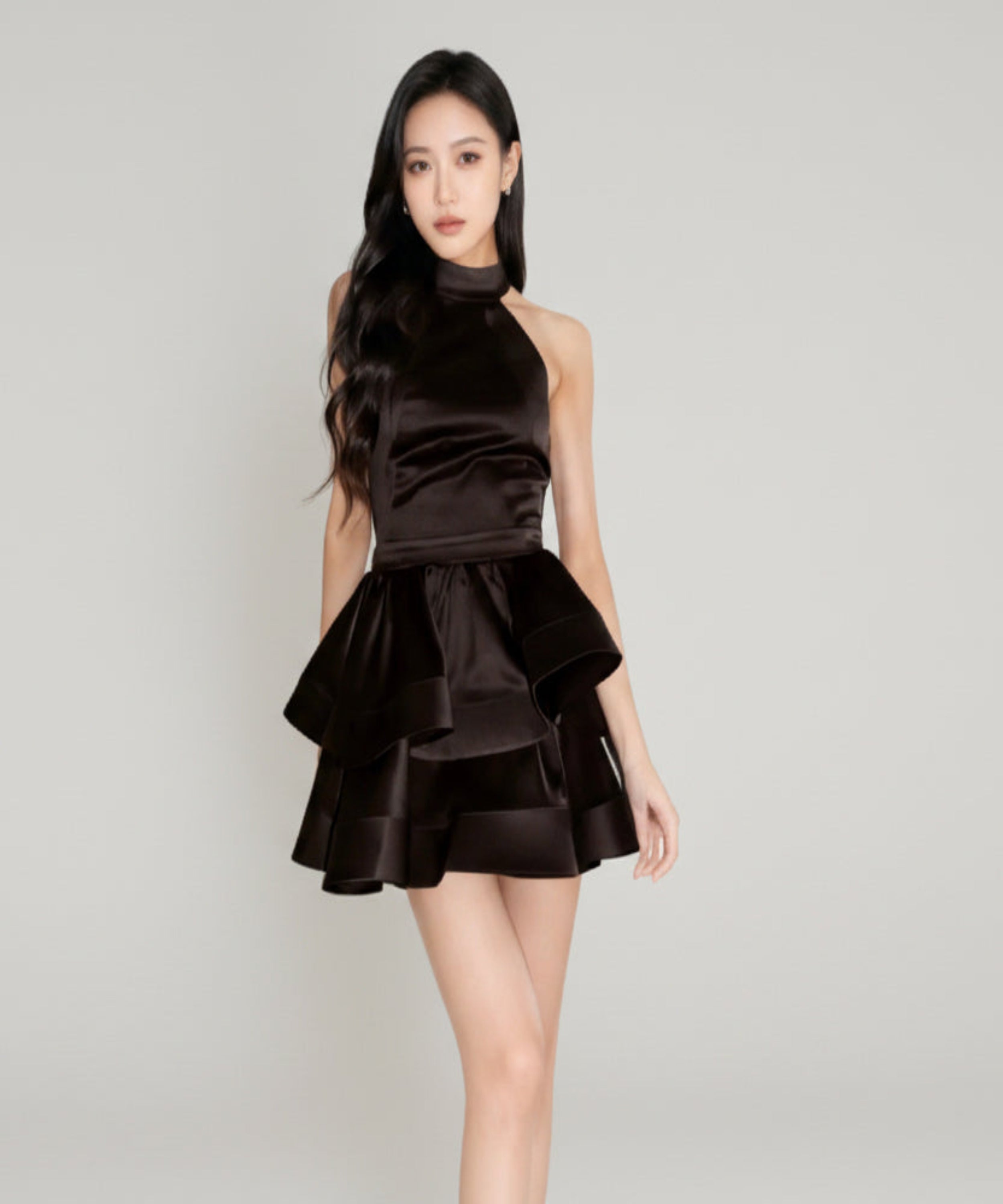 Woman wearing a black dress on a light grey background