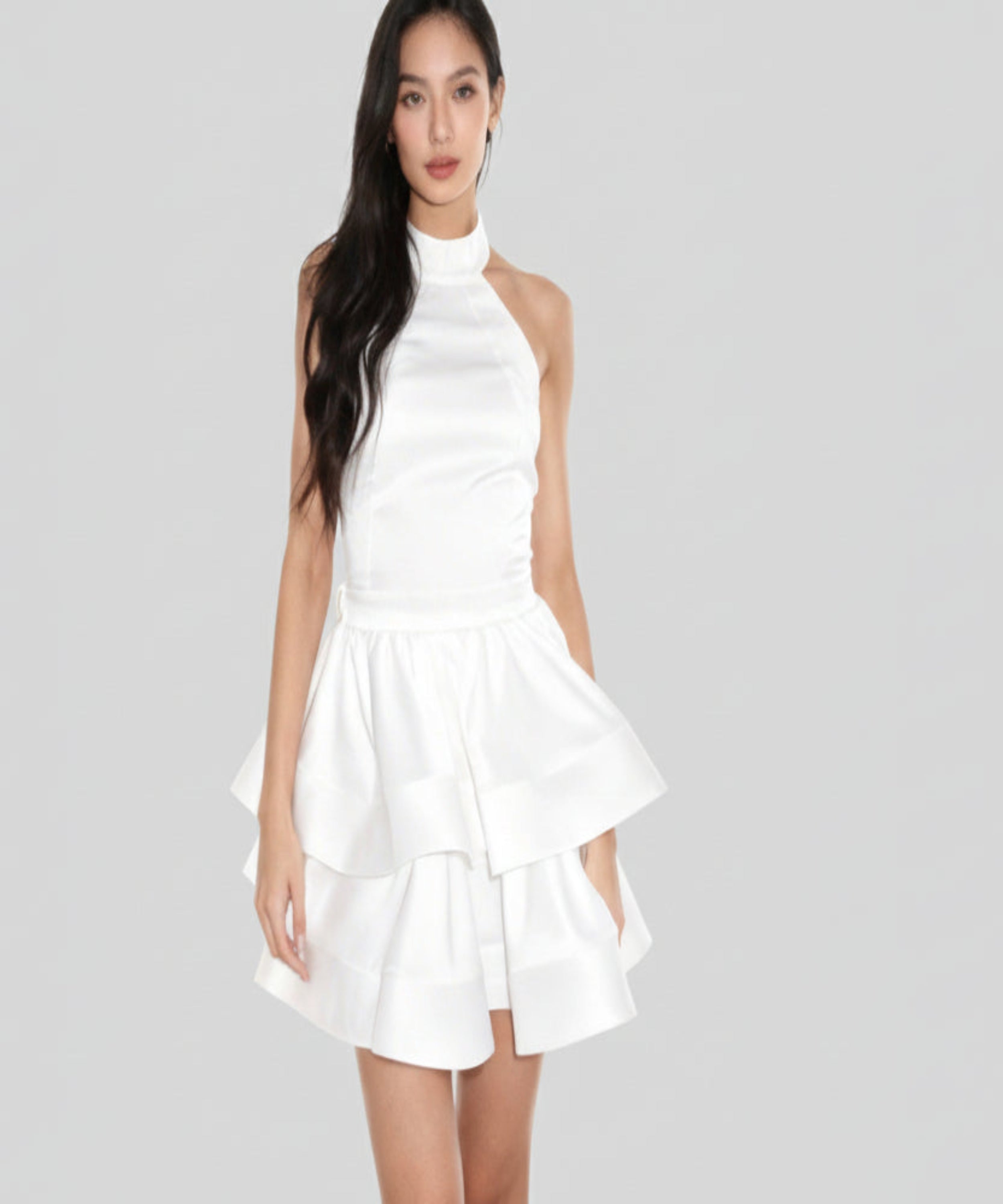 Woman wearing a white dress on a light grey background