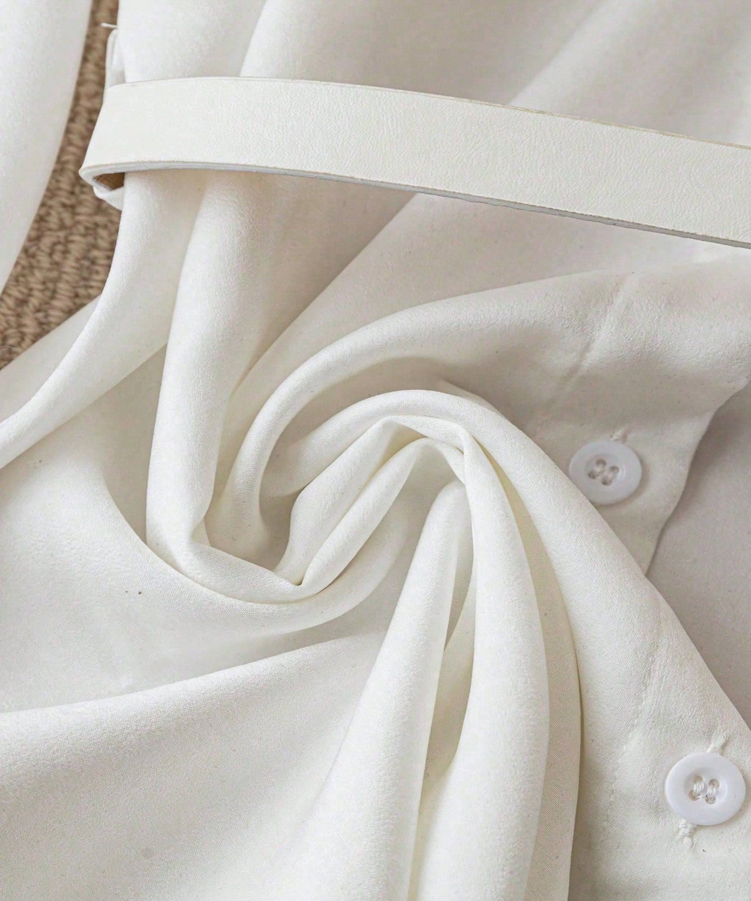 Close-up of a white shirt with buttons on a textured surface